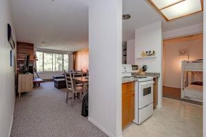 eine Küche und ein Wohnzimmer mit einem Tisch in der Unterkunft The Great Escape–2 Bdrm w/Private Sauna in Village in Big White
