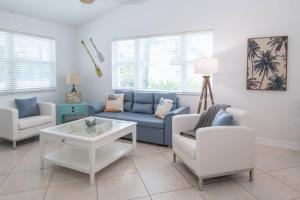 a living room with a couch and a table and chairs at Steps to Private Beach - Sand, Surf, Sun - 2bd,2ba in Fort Pierce