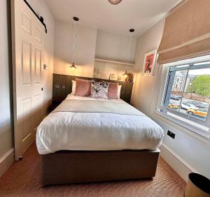 a bedroom with a large bed and a window at Rooms Above Sugar Boat in Helensburgh
