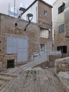 un antiguo edificio con una cancha de baloncesto y un aro de baloncesto en Dar Jacaman - In the heart of Bethlehem old city, en Bethlehem