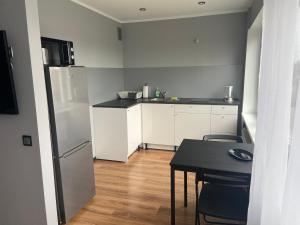 uma pequena cozinha com uma mesa e um frigorífico em Akropole Apartment em Riga