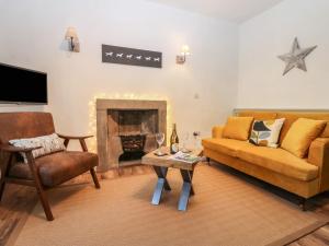 a living room with a couch and a fireplace at Teal Cottage in Leyburn
