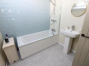a bathroom with a sink and a tub and a toilet at Teal Cottage in Leyburn +18 photos
