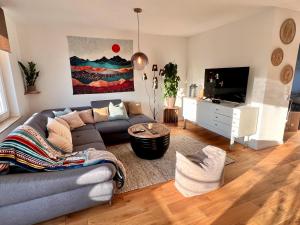 sala de estar con sofá y TV en Penthouse Outlet Metzingen en Metzingen