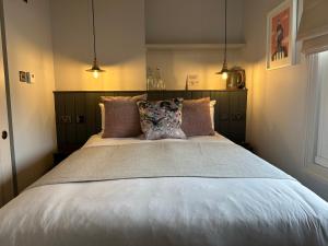 1 dormitorio con 1 cama grande con almohadas en Rooms Above Sugar Boat, en Helensburgh
