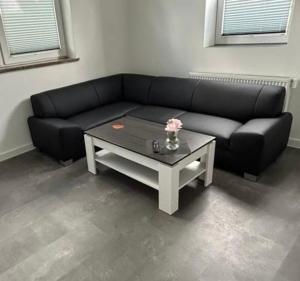 a living room with a black couch and a coffee table at MR Ferienwohnung - Wohnung Mila 