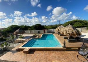 a swimming pool with umbrellas and a resort at Pura Vida Aruba appartement Cama in Noord