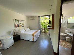 a bedroom with a bed and a bathroom at Yucca Pousada in Arraial d'Ajuda