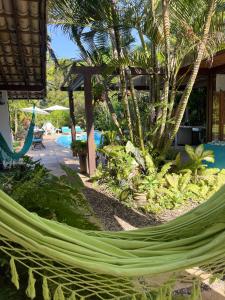 a hammock in front of a resort with a pool at Yucca Pousada in Arraial d'Ajuda