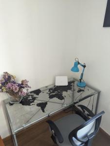 a glass desk with a lamp and a chair at Alghero, old town in Alghero