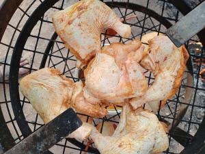 a chicken is cooking on a grill with a knife at Petra Anas House in Wadi Musa