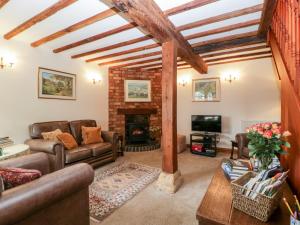 sala de estar con sofás y chimenea en Poplar Cottage, en Evesham