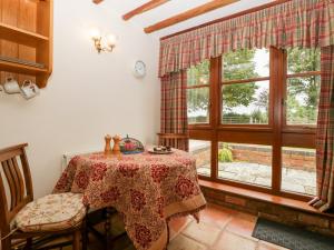 a dining room with a table and a window at Poplar Cottage in Evesham