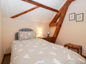 a bedroom with a white bed with a blue chair at Poplar Cottage in Evesham