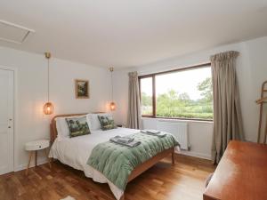 sypialnia z łóżkiem i dużym oknem w obiekcie Orchard End w mieście Glastonbury