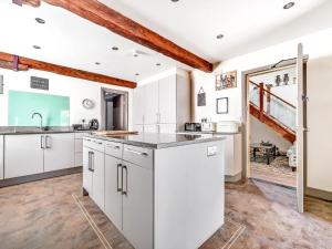 een keuken met witte kasten en een houten vloer bij Eden Mill, Millers Beck in Kendal