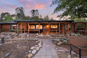 a log home with a patio and a yard at Sky Ranch Log Cabin with Amazing Views! in Wofford Heights
