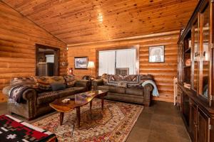 una sala de estar con sofás y una mesa en una cabaña en Sky Ranch Log Cabin with Amazing Views!, en Wofford Heights
