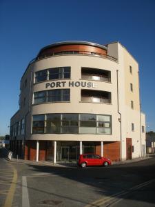 Wild Atlantic Apartments Port House Letterkenny في ليتيركيني: سيارة حمراء متوقفة أمام منزل الميناء