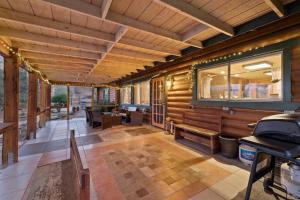 Habitación grande con paredes de madera y bancos en una casa en Sky Ranch Log Cabin with Amazing Views!, en Wofford Heights