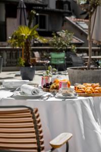 una mesa con un mantel blanco con comida. en Belle Epoque, en Aix-les-Bains