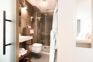 a bathroom with a shower and a toilet and a sink at De DroomBoutique - Goud & Zilver Suites in Gorinchem +19 photos
