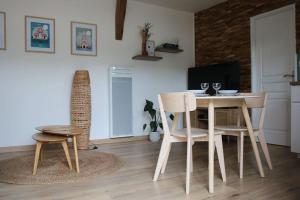 a living room with a table and chairs and a television at Gîte 4 étoiles avec SPA privatif in Méaulte