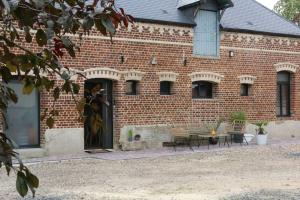 a brick building with a table and chairs in front of it at Gîte 4 étoiles avec SPA privatif in Méaulte