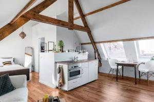 cocina y sala de estar con armarios blancos y mesa en BBWestduin, en La Haya