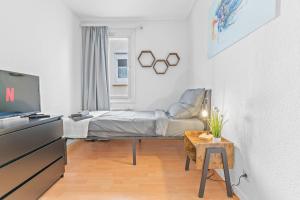 a bedroom with a bed and a table and a tv at ES03 Top Wohnung für 6 Personen in Oberesslingen