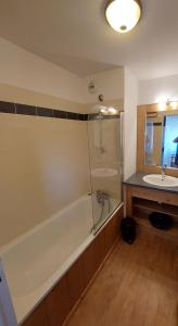 a bathroom with a bath tub and a sink at HIVER COMME ETE in Forest des Baniols