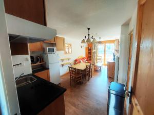 a kitchen and dining room with a table and a kitchen with a dining room at HIVER COMME ETE in Forest des Baniols