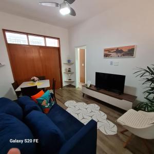 a living room with a blue couch and a tv at Apartamento Sandy-Zona Sul in Rio de Janeiro