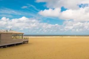 un edificio en una playa con el océano en BBWestduin, en La Haya