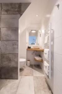 a white bathroom with a sink and a toilet at BBWestduin in The Hague