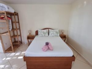 a bedroom with a bed with a pair of shoes on it at Fare alizés in Mahina