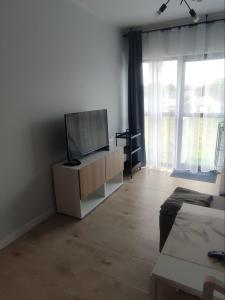 a living room with a flat screen tv on a cabinet at Błękitne zacisze in Gdańsk