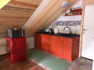 uma cozinha com armários vermelhos e um frigorífico vermelho em Versay Apartment em Pušćina