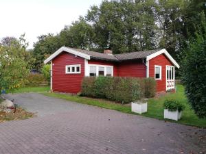 a red house with a driveway in front of it at Gästehaus an der Surheide in Ottersberg