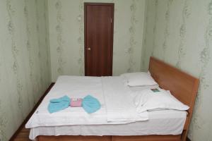 a bed with two blue bow ties on it at Монтана in Petropavlovsk