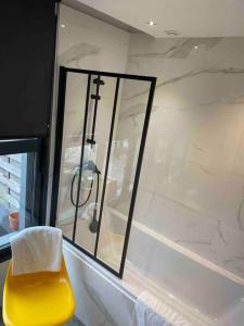 een gele stoel naast een raam in een badkamer bij Loft sur les toits de Roubaix in Roubaix +3 foto's