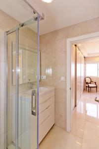 a bathroom with a glass shower and a sink at The White Apartment: Luxury, Beach and Design in Valencia