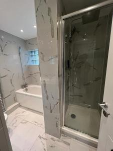 a bathroom with a shower with a glass door at Luxurious apartment in Central London in London