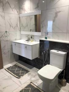 a bathroom with a toilet and a sink and a mirror at Super appartement avec 5 piscines en résidence in Monastir