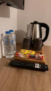 a remote control sitting on a table with a tea pot and water at Well Hotel Edirne in Edirne