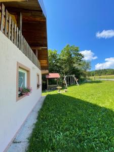 a building with a yard with a playground in the background at Vikendica Jovanovic in Bajina Bašta