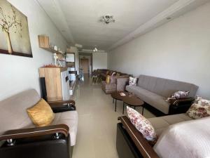una sala de estar con sofás y mesas. en appartement chic et ensoleillé ola blanca 2, en Dar Hamida