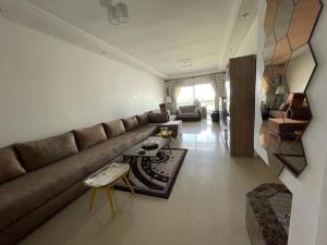 sala de estar con sofá y mesa en appartement chic et ensoleillé ola blanca 2, en Dar Hamida