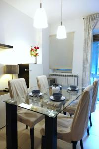ein Esszimmer mit einem Glastisch und weißen Stühlen in der Unterkunft Metro Bengasi Torino Lingotto Premium location - eXpress traveler spazioso - Grand Maison in Turin