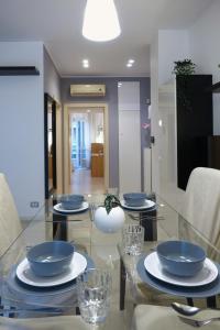 einem Glastisch mit blauen Schalen und Platten darauf in der Unterkunft Metro Bengasi Torino Lingotto Premium location - eXpress traveler spazioso - Grand Maison in Turin